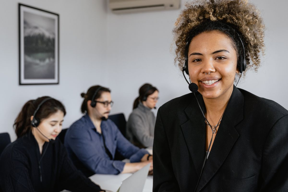 Smiling support agent at a desk wearing a headset
